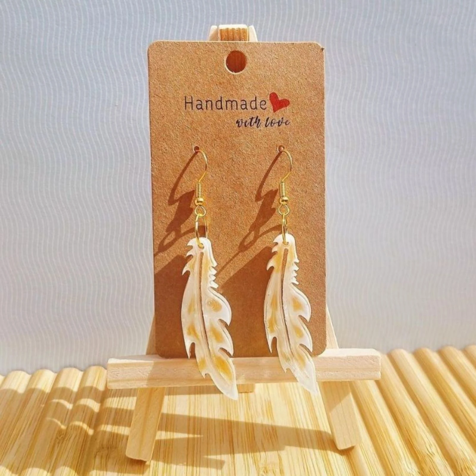 Boucles d'oreilles plumes blanches dorées 
